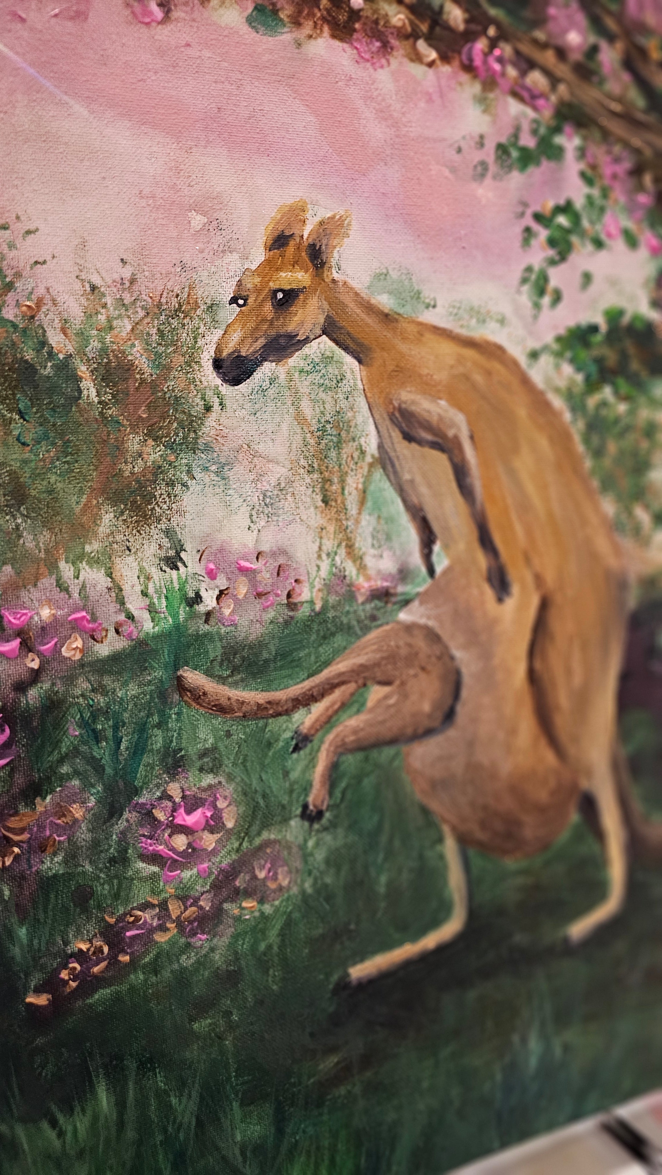 Original Painting by Shelley Bailey of a kangaroo in a garden with flowers and trees. Joey bounds into mother's pouch.