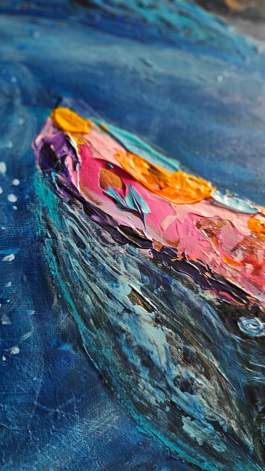 Close-up of a colorful whale painting with blue and pink tones. 